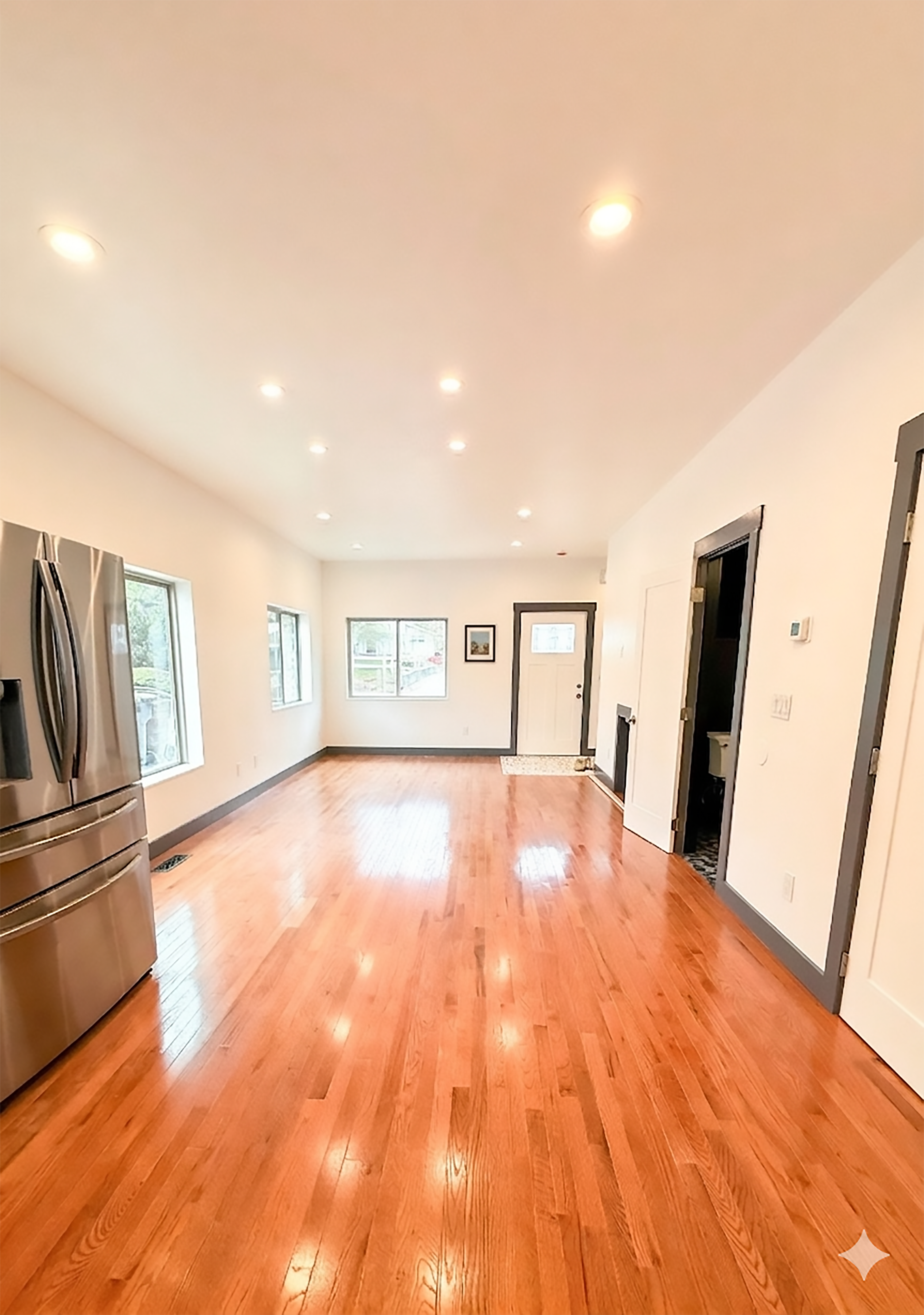 Main living area with hardwood floors and recessed lighting.